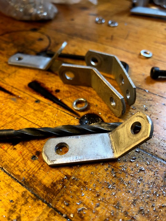 Hand-made brackets reshaped from cushion mounts pulled from vintage Samsonite folding chairs